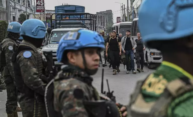 M23 rebels escort Romanian mercenaries past UN peacekeepers to the border crossing into Rwanda in Goma, Democratic Republic of Congo, Wednesday, Jan. 29, 2025.(AP Photo/Moses Sawasawa)