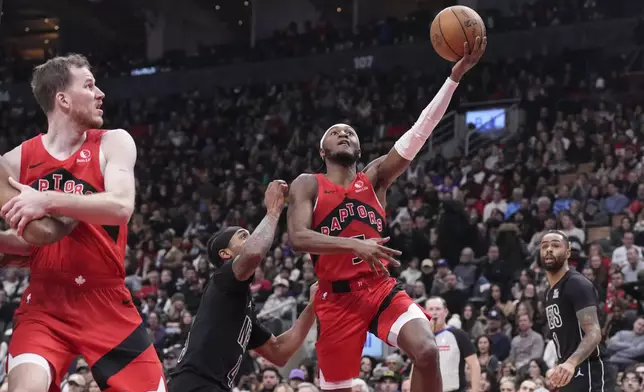 Toronto Raptors' Immanuel Quickley (5) shoots past Brooklyn Nets' Keon Johnson (45) during the first half of an NBA basketball game in Toronto on Wednesday, Jan. 1, 2025. (Chris Young/The Canadian Press via AP)