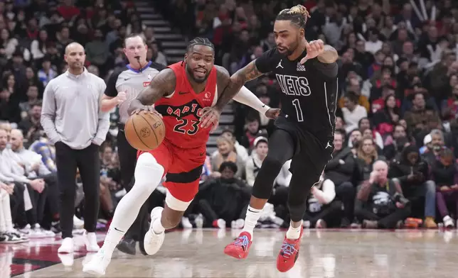 Toronto Raptors' Jamal Shead (23) drives past Brooklyn Nets' D'Angelo Russell (1) during the first half of an NBA basketball game in Toronto on Wednesday, Jan. 1, 2025. (Chris Young/The Canadian Press via AP)