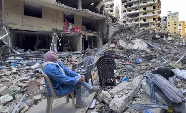 FILE - A woman sits amid the rubble of a building destroyed by an Israeli airstrike in Dahiyeh, in the southern suburb of Beirut, Lebanon, Nov. 11, 2024. (AP Photo/Hussein Malla, File)