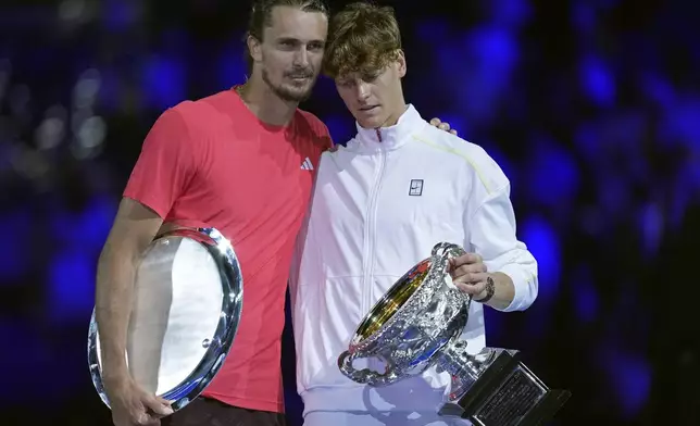 Jannik Sinner, right, of Italy holds the Norman Brookes Challenge Cup after defeating Alexander Zverev of Germany in the men's singles final at the Australian Open tennis championship in Melbourne, Australia, Sunday, Jan. 26, 2025. (AP Photo/Ng Han Guan)
