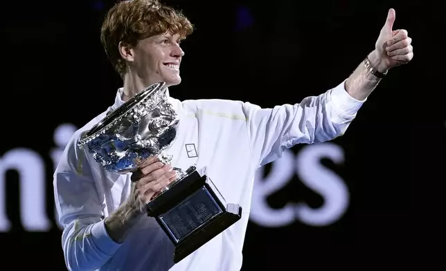 Jannik Sinner of Italy gestures as he carries the Norman Brookes Challenge Cup after defeating Alexander Zverev of Germany in the men's singles final at the Australian Open tennis championship in Melbourne, Australia, Sunday, Jan. 26, 2025. (AP Photo/Asanka Brendon Ratnayake)