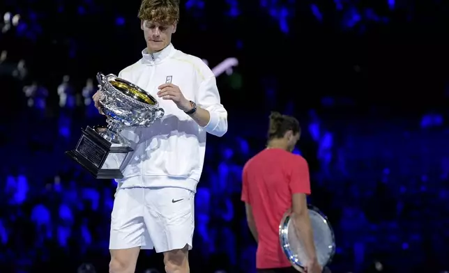 Jannik Sinner of Italy holds the Norman Brookes Challenge Cup after defeating Alexander Zverev, right, of Germany in the men's singles final at the Australian Open tennis championship in Melbourne, Australia, Sunday, Jan. 26, 2025. (AP Photo/Asanka Brendon Ratnayake)