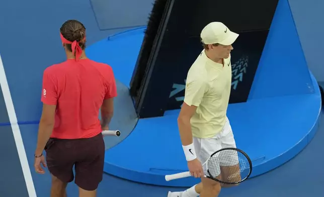 Jannik Sinner of Italy, right, and Alexander Zverev of Germany walk past each other during the men's singles final at the Australian Open tennis championship in Melbourne, Australia, Sunday, Jan. 26, 2025. (AP Photo/Manish Swarup)