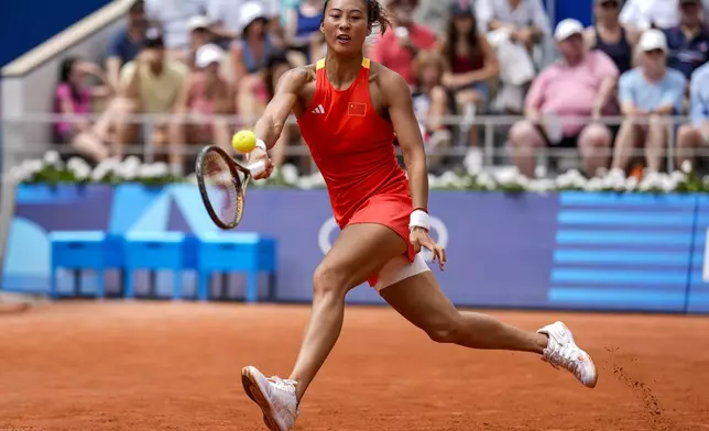 FILE - Qinwen Zheng of China returns the ball against Iga Swiatek of Poland during their women's semifinals match at the Roland Garros stadium, at the 2024 Summer Olympics, Thursday, Aug. 1, 2024, in Paris, France. (AP Photo/Manu Fernandez, File)