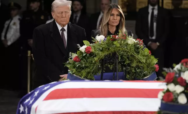 President-elect Donald Trump and Melania Trump pause at the flag-draped casket of former President Jimmy Carter as he lies in state in the rotunda of the U.S. Capitol in Washington, Wednesday, Jan. 8, 2025. (AP Photo/J. Scott Applewhite