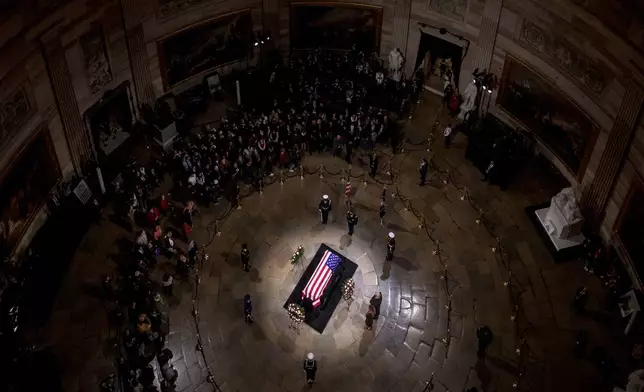 President-elect Donald Trump and Melania Trump pause at the flag-draped casket of former President Jimmy Carter as he lies in state in the rotunda of the U.S. Capitol in Washington, Wednesday, Jan. 8, 2025. (Andrew Harnik/Pool via AP)