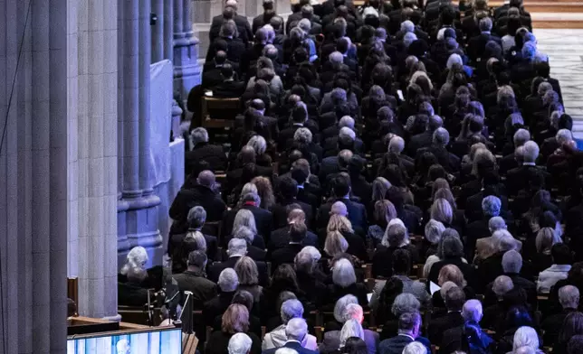 Guests listen as President Joe Biden, seen on screen, delivers remarks during the state funeral of former President Jimmy Carter at the National Cathedral, Thursday, Jan. 9, 2025, in Washington. (Haiyun Jiang/The New York Times via AP, Pool)