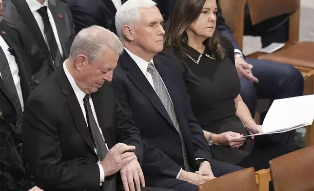 Former Vice President Al gore sits with former Vice President Mike Pence and his wife Karen before the state funeral for former President Jimmy Carter at Washington National Cathedral in Washington, Thursday, Jan. 9, 2025. (AP Photo/Jacquelyn Martin)