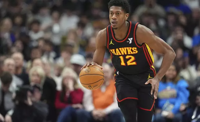 Atlanta Hawks forward De'Andre Hunter collects a loose ball in the first half of an NBA basketball game against the Denver Nuggets Wednesday, Jan. 1, 2025, in Denver. (AP Photo/David Zalubowski)