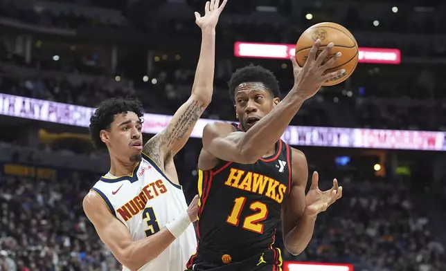 Atlanta Hawks forward De'Andre Hunter, right, collects the ball as Denver Nuggets guard Julian Strawther defends in the first half of an NBA basketball game Wednesday, Jan. 1, 2025, in Denver. (AP Photo/David Zalubowski)