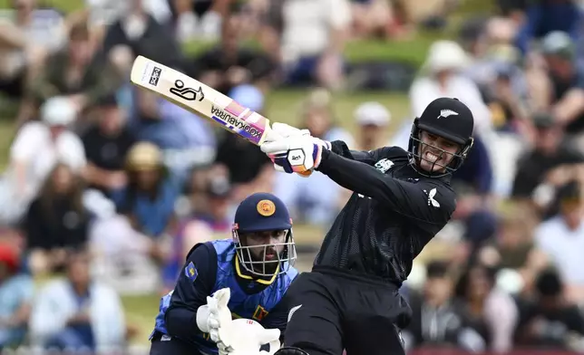 New Zealand's Mark Chapman, right, bats in front of Sri Lanka's Kusal Mendis during their one day international cricket match in Hamilton, New Zealand. Wednesday, Jan. 8, 2025. (Andrew Cornaga/Photosport via AP)