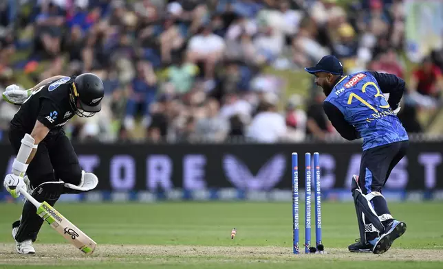 Sri Lanka wicketkeeper Kusal Mendis, right, runs out New Zealand's Tom Latham, left, during their one day international cricket match in Hamilton, New Zealand. Wednesday, Jan. 8, 2025. (Andrew Cornaga/Photosport via AP)