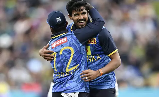 Sri Lanka bowler Maheesh Theekshana, right, celebrates his hat-trick with his captain Charith Asalanka during their one day international cricket match against New Zealand in Hamilton, New Zealand. Wednesday, Jan. 8, 2025. (Andrew Cornaga/Photosport via AP)