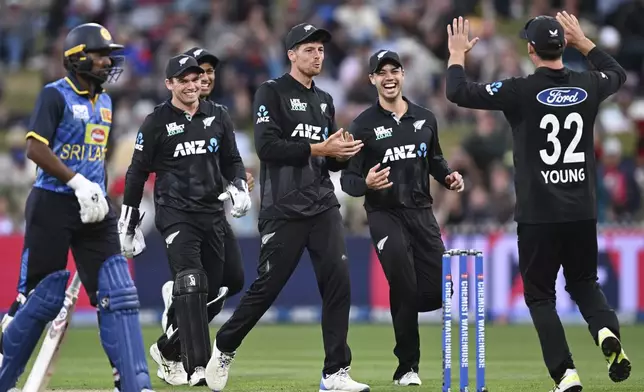 New Zealand players celebrate the wicket of Sri Lanka captain Charith Asalanka during their one day international cricket match in Hamilton, New Zealand. Wednesday, Jan. 8, 2025. (Andrew Cornaga/Photosport via AP)