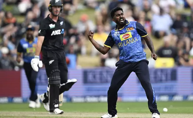 Sri Lanka's Asitha Fernando, right, celebrates the wicket of New Zealand's Will Young, left, during their one day international cricket match in Hamilton, New Zealand. Wednesday, Jan. 8, 2025. (Andrew Cornaga/Photosport via AP)