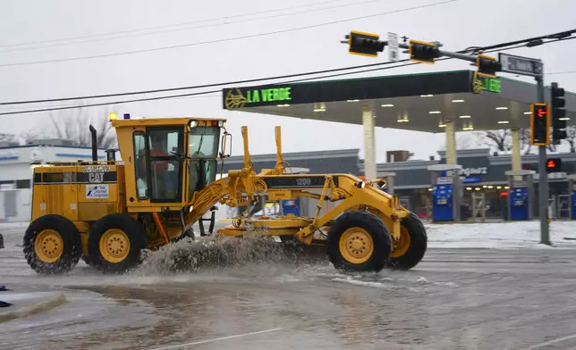 Slush is plowed on a street during a winter storm, Thursday, Jan. 9, 2025, in Arlington, Texas. (AP Photo/Julio Cortez)