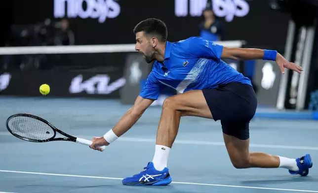 Novak Djokovic of Serbia plays a backhand return to Tomas Machac of the Czech Republic during their third round match at the Australian Open tennis championship in Melbourne, Australia, Friday, Jan. 17, 2025. (AP Photo/Asanka Brendon Ratnayake)