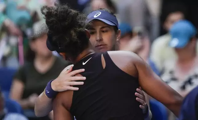 Naomi Osaka of Japan is embraced by Belinda Bencic, right, of Switzerland after she retired from their third round match at the Australian Open tennis championship in Melbourne, Australia, Friday, Jan. 17, 2025. (AP Photo/Manish Swarup)