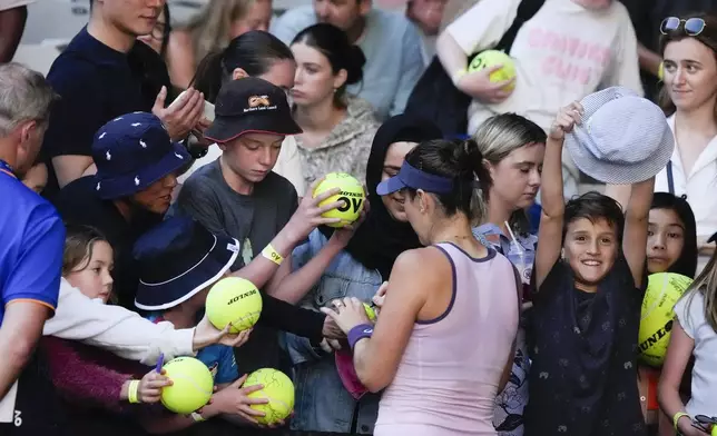 Belinda Bencic of Switzerland signs autographs following her third round match against Naomi Osaka of Japan at the Australian Open tennis championship in Melbourne, Australia, Friday, Jan. 17, 2025. (AP Photo/Manish Swarup)