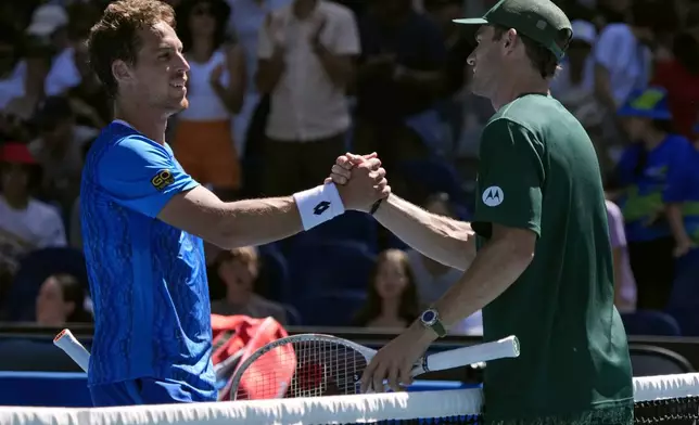 Tommy Paul, right, of the U.S. is congratulated by Roberto Carballes Baena of Spain following their third round match at the Australian Open tennis championship in Melbourne, Australia, Friday, Jan. 17, 2025. (AP Photo/Manish Swarup)