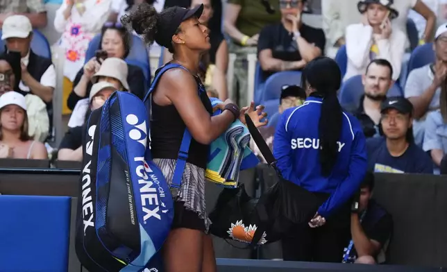 Naomi Osaka of Japan leaves the court after retiring from her third round match against Belinda Bencic of Switzerland at the Australian Open tennis championship in Melbourne, Australia, Friday, Jan. 17, 2025. (AP Photo/Manish Swarup)