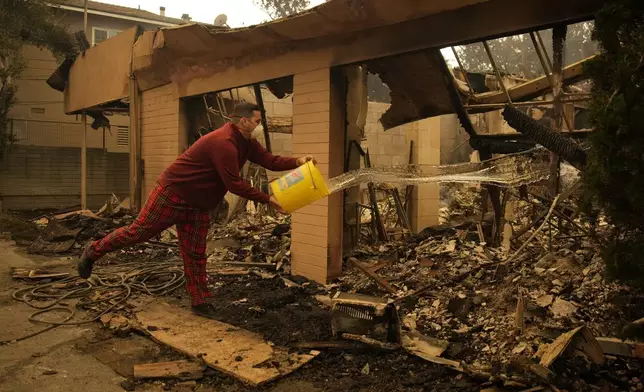 Shane Torre douses hot spots of what remains of his home In Altadena, Calif., Thursday, Jan. 9, 2025. (AP Photo/John Locher)