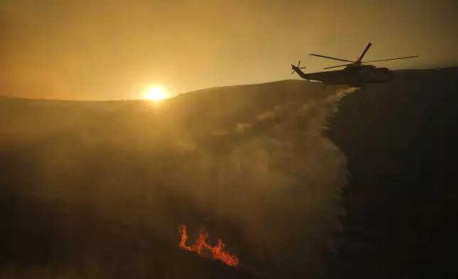 A helicopter flies over the Kenneth Fire, Thursday, Jan. 9, 2025, in the West Hills section of Los Angeles. (AP Photo/Eric Thayer)