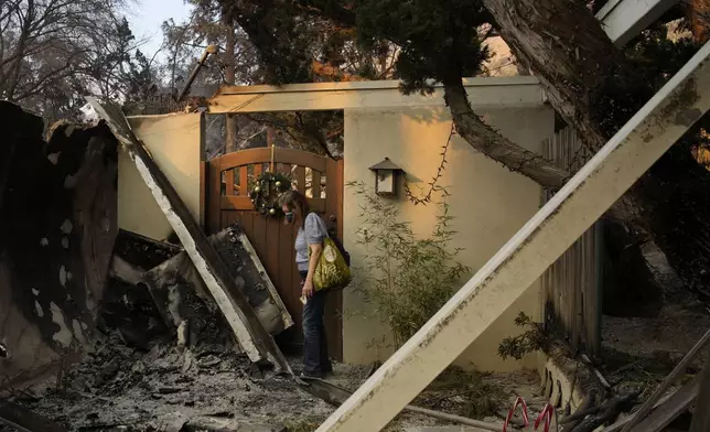 Glenda, who declined to give her last name, stands near the entrance of her home destroyed by the Eaton fire Thursday, Jan. 9, 2025, in Altadena, Calif. (AP Photo/John Locher)