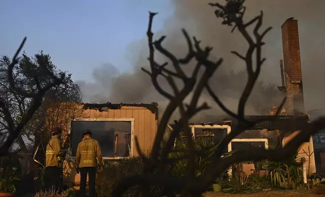 Firefighters look over a home after the Eaton Fire burns in Altadena, Calif., Thursday, Jan. 9, 2025. (AP Photo/Nic Coury)