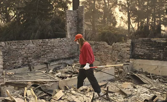 A man searches though his destroyed home after the Eaton Fire in Altadena, Calif., Thursday, Jan. 9, 2025. (AP Photo/Nic Coury)