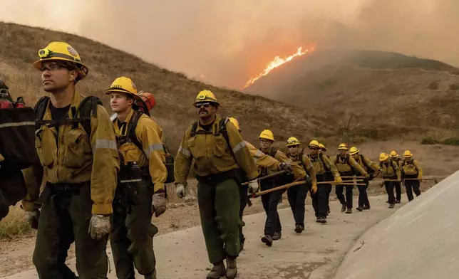 Fire crews battle the Kenneth Fire in the West Hills section of Los Angeles, Thursday, Jan. 9, 2025. (AP Photo/Ethan Swope)