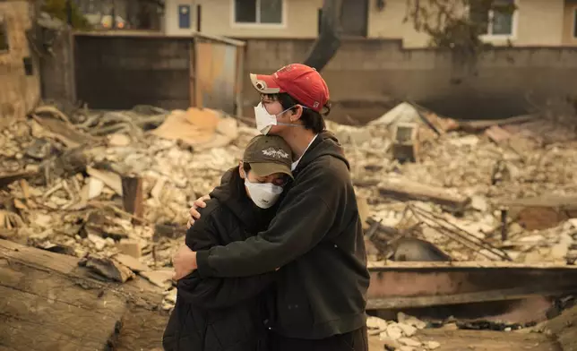 Ari Rivera, right, and Anderson Hao hold each other in front of their destroyed home in Altadena, Calif., Thursday, Jan. 9, 2025. (AP Photo/John Locher)