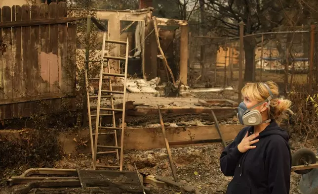 Lissa Renn looks at remains of her neighborhood In Altadena, Calif., Thursday, Jan. 9, 2025. (AP Photo/John Locher)