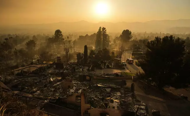 An emergency vehicle drives through a neighborhood devastated by the Eaton Fire, Thursday, Jan. 9, 2025, in Altadena, Calif. (AP Photo/John Locher)