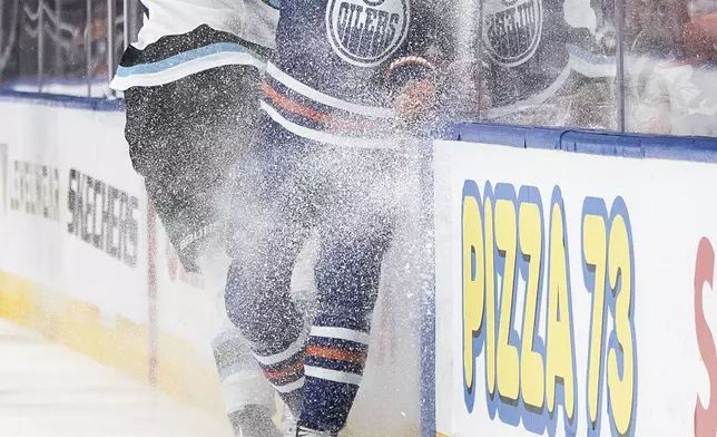 Utah Hockey Club's Michael Kesselring (7) checks Edmonton Oilers' Darnell Nurse (25) during the third period of an NHL hockey game in Edmonton, Alberta on Tuesday, Dec. 31, 2024. (Jason Franson/The Canadian Press via AP)