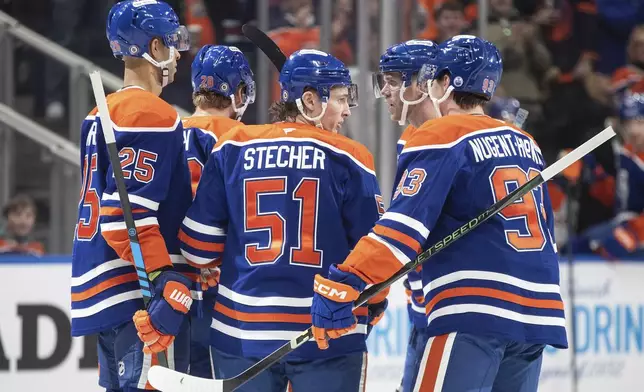 Edmonton Oilers' Darnell Nurse (25), Connor Brown (28), Troy Stecher (51), Connor McDavid (97) and Ryan Nugent-Hopkins (93) celebrate a goal against the Utah Hockey Club during the second period of an NHL hockey game in Edmonton, Alberta on Tuesday, Dec. 31, 2024. (Jason Franson/The Canadian Press via AP)