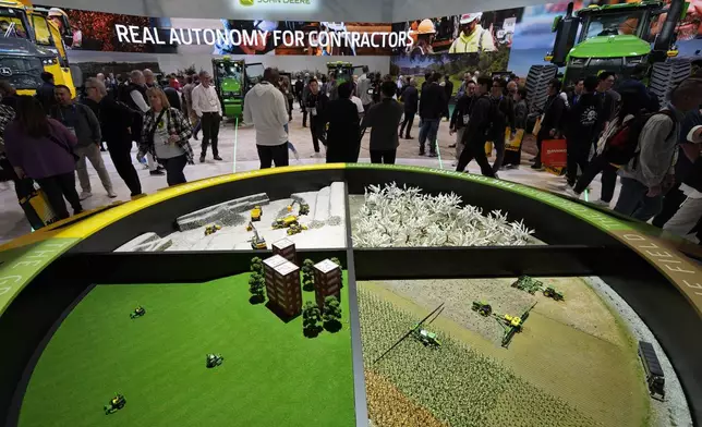 People visit the John Deere booth during the CES tech show Tuesday, Jan. 7, 2025, in Las Vegas. (AP Photo/John Locher)