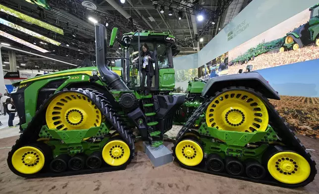 A convention goer exits a John Deere 9RX Tractor at the John Deere booth during the CES tech show Tuesday, Jan. 7, 2025, in Las Vegas. (AP Photo/John Locher)