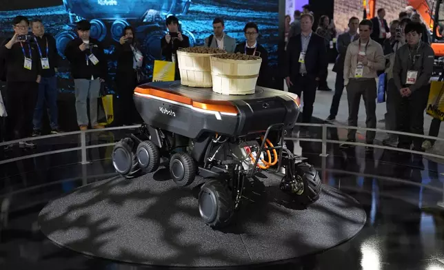 People view a demonstration of the KATR robot designed to work in agriculture and construction at the Kubota booth during the CES tech show Tuesday, Jan. 7, 2025, in Las Vegas. (AP Photo/John Locher)