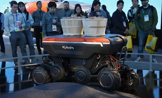 People view a demonstration of the KATR robot designed to work in agriculture and construction at the Kubota booth during the CES tech show Tuesday, Jan. 7, 2025, in Las Vegas. (AP Photo/John Locher)