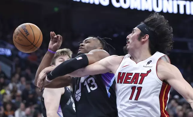 Utah Jazz guard Isaiah Collier (13) and Miami Heat guard Jaime Jaquez Jr. (11) battle for a rebound during the second quarter of an NBA basketball game, Thursday, Jan. 9, 2025, in Salt Lake City. (AP Photo/Rob Gray)