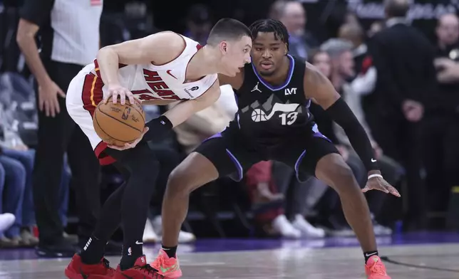 Miami Heat guard Tyler Herro (14) holds the ball away from Utah Jazz guard Isaiah Collier (13) during the second half of an NBA basketball game, Thursday, Jan. 9, 2025, in Salt Lake City. (AP Photo/Rob Gray)