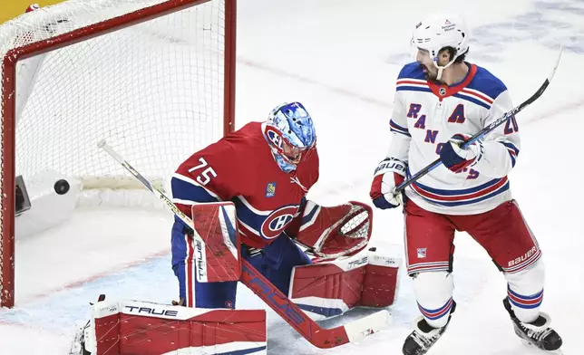 New York Rangers' Chris Kreider, right, looks for a rebound as Montreal Canadiens goaltender Jakub Dobes (75) is scored against by Rangers' Mika Zibanejad during second-period NHL hockey game action in Montreal, Sunday, Jan. 19, 2025. (Graham Hughes/The Canadian Press via AP)