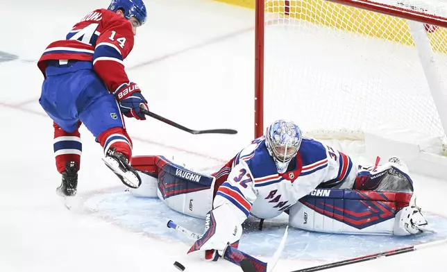 New York Rangers goaltender Jonathan Quick (32) stops Montreal Canadiens' Nick Suzuki (14) during second-period NHL hockey game action in Montreal, Sunday, Jan. 19, 2025. (Graham Hughes/The Canadian Press via AP)