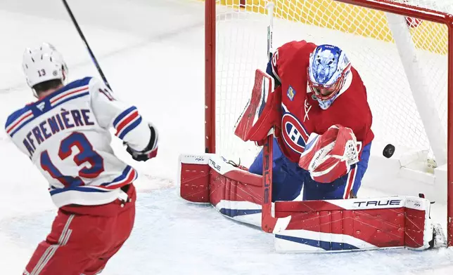 New York Rangers' Alexis Lafreniere, left, scores on Montreal Canadiens goaltender Jakub Dobes during the first period of an NHL hockey game in Montreal, Sunday, Jan. 19, 2025. (Graham Hughes/The Canadian Press via AP)