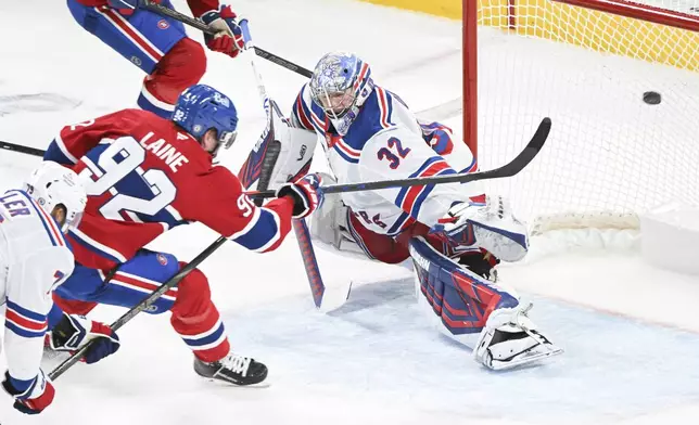 Montreal Canadiens' Patrik Laine (92) scores against New York Rangers goaltender Jonathan Quick (32) during overtime period NHL hockey game action in Montreal, Sunday, Jan. 19, 2025. (Graham Hughes/The Canadian Press via AP)