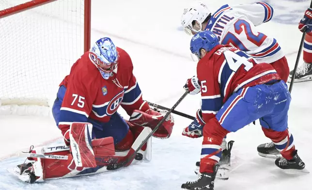 Montreal Canadiens goaltender Jakub Dobes (75) stops New York Rangers' Filip Chytil as Canadiens' Alexandre Carrier (45) defends during the second period of an NHL hockey gamein Montreal, Sunday, Jan. 19, 2025. (Graham Hughes/The Canadian Press via AP)