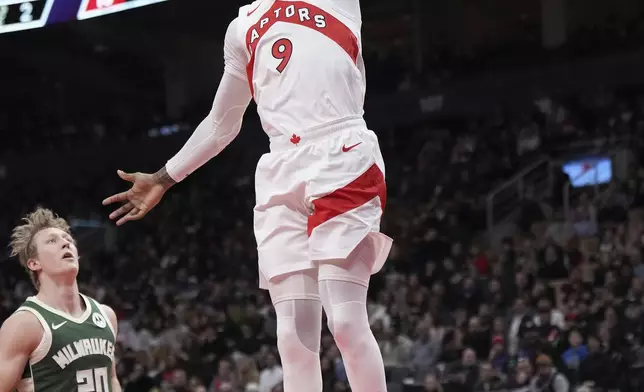 Toronto Raptors guard RJ Barrett (9) dunks the ball past Milwaukee Bucks guard AJ Green (20) during the first half of an NBA basketball game in Toronto, Monday, Jan. 6, 2025. (Nathan Denette/The Canadian Press via AP)