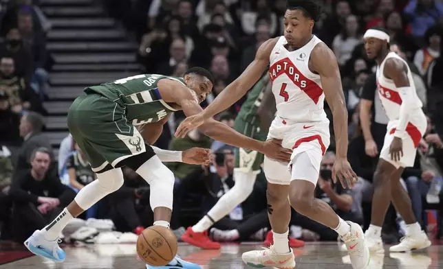 Toronto Raptors forward Scottie Barnes (4) steals the ball from Milwaukee Bucks forward Giannis Antetokounmpo during the first half of an NBA basketball game in Toronto, Monday, Jan. 6, 2025. (Nathan Denette/The Canadian Press via AP)